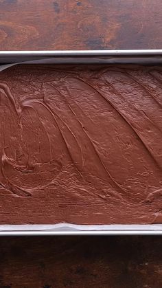 chocolate frosted cake sitting on top of a wooden table