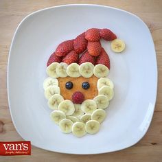 a white plate topped with fruit and a face made out of bananas, strawberries and kiwis