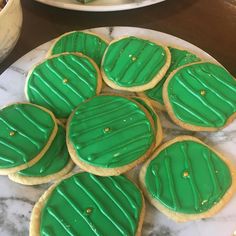 green frosted cookies sitting on top of a white plate