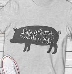 a shirt with the words life is better with a pig on it next to a pair of sneakers