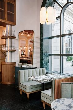 the interior of a restaurant with tables and chairs in front of a large glass window