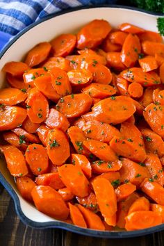 a white bowl filled with cooked carrots and parsley