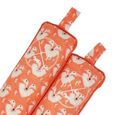 two pieces of luggage with an animal pattern on them, one is orange and the other is white