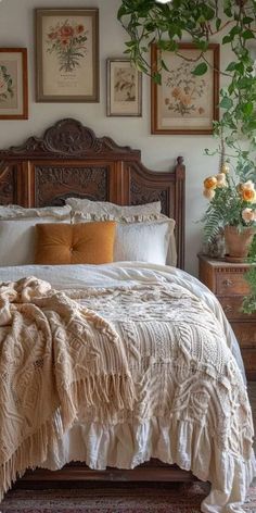 a large bed sitting in a bedroom next to two potted plants on either side of the bed