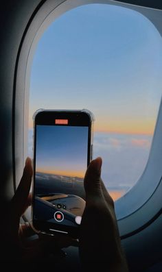 someone is taking a photo of the view from an airplane window with their cell phone