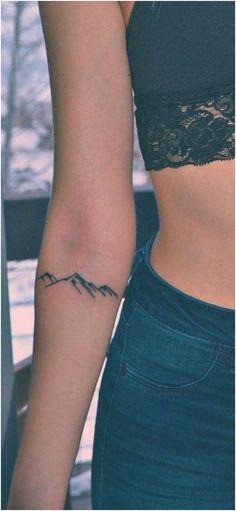 a woman's arm with a tattoo on it that says mountain and the word