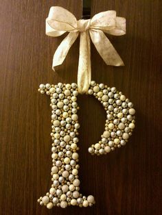 the letter p is made out of beads and bows on top of a wooden table