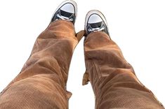 the bottom view of a person's feet wearing brown corduros and sneakers