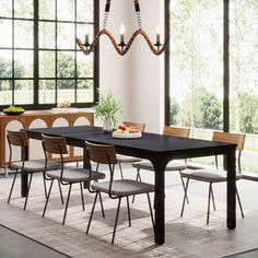 a dining room table with six chairs and a chandelier hanging from the ceiling