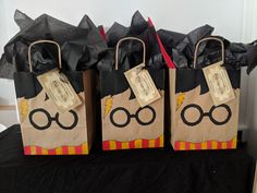 three bags with harry potter characters on them are sitting on a black cloth covered table