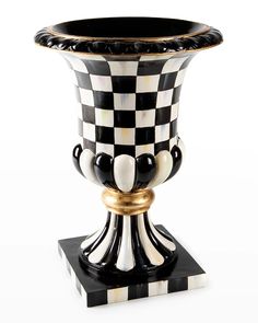 a black and white vase sitting on top of a stand