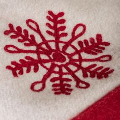 a red and white towel with a snowflake embroidered on it