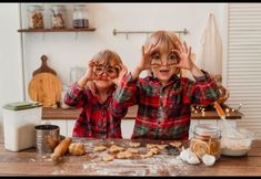 two young children making cookies in the kitchen