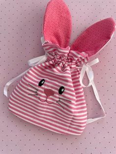 a pink and white striped bag with a bunny face on it