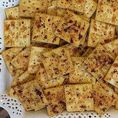 a white plate topped with lots of crackers on top of a doily covered table