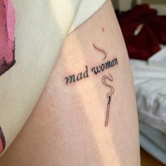 a woman with a tattoo on her arm that reads mad woman and has a hook in it