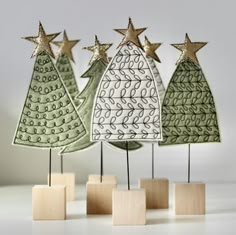 three small wooden christmas trees with gold stars on them, one is green and the other is white