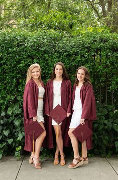 three women in graduation gowns posing for the camera