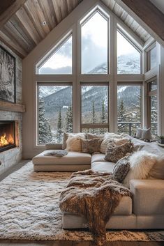 a living room filled with furniture and a fire place in front of a large window