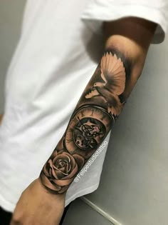 a man's arm with a clock and roses on it