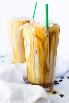 two glasses filled with iced coffee on top of a white table cloth covered in black dots