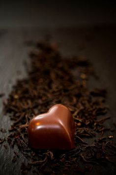 a heart shaped chocolate on top of some tea