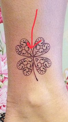 a woman's foot with a butterfly tattoo on the side of her leg and red string attached to it