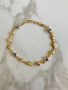 "Perfect worn on its own or layered with our other bracelets. 18k gold filled. Cubic zirconia 7\" length Ready to ship *18k gold filled is a more affordable alternative to solid gold jewelry. Gold filled is a layer of gold bonded onto a base metal with heat and pressure that contains 100+ times more gold than gold plated jewelry.  *It is very durable and tarnish resistant.  *With proper care, gold filled jewelry can last several years. Avoid contact with harsh chemicals, perfumes, water, etc.  *Gold filled jewelry can be worn by people with sensitive skin because it is hypoallergenic, lead free and nickel free." Blue And Gold Bracelets, Gold Star Bracelets For Everyday, Gold Star-shaped Celestial Bracelets, Adjustable Gold Celestial Charm Bracelet, 14k Gold Bracelet With Star Charm, Gold Star-shaped Celestial Bracelet, Celestial Gold Star Bracelets, How To Layer Bracelets, Gold And Blue Jewelry