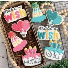 three decorated cookies in a box with words on them and decorations around the edges that spell out wish