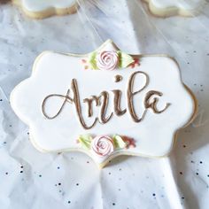 decorated cookies with the word amie written on them are sitting on a white tablecloth