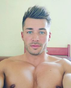 a shirtless man with blue eyes and no shirt on is posing for the camera