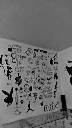 black and white photograph of wall with various stickers on it