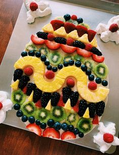 a decorated cake with fruit on it sitting on top of a pan