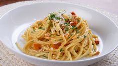 a white bowl filled with pasta and parmesan cheese on top of a table