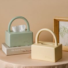 two small purses sitting on top of a table next to books and other items