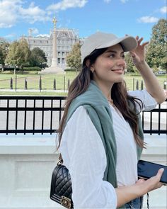 a woman wearing a hat and holding a purse