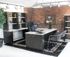 an office with brick walls and black desks in the center, surrounded by potted plants