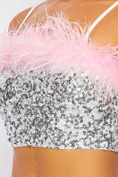 Dazzling sequins and pink feathers pave the way on this spectacular crop that's sure to be a hit from celebrations to nights on the town. • Pink Feather Trim• Adj. Straps• Pull On• Crop• Silver Sequins