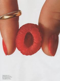 a woman's hand with red nail polish and ring