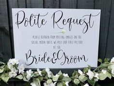 a sign that says polite request on the side of a fence with flowers around it