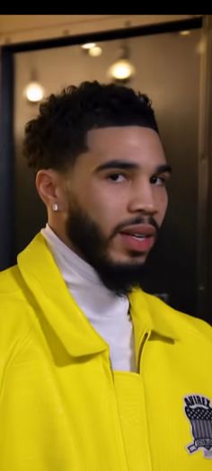 a man with a beard wearing a yellow jacket