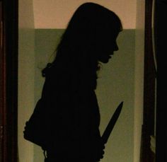 the silhouette of a woman holding a knife