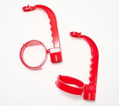 a pair of red plastic scissors on a white background with clippings for the handles