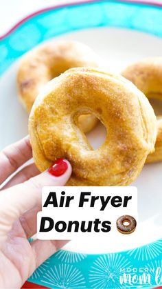 two donuts on a plate being held by a hand