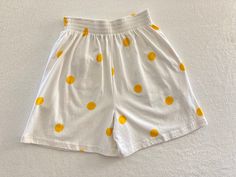 Vintage 1990's white summery elastic waist wide leg shorts with large yellow polka dots and yellow bow on back pocket by Betty Blue Made in Portugal 100% Cotton Good vintage condition with no rips or stains Tag shows Medium Measurements (laying flat): Waist: 13" - 16" Rise: 15" Length: 18 1/4" Inseam: 5 1/4" Our items are vintage, older and/or pre-loved and may show signs of age. Items may have some imperfections, including small holes, marks or stains. We do our best to note all flaws and pictu Polka Dot Summer Bottoms With Pockets, Polka Dot Bottoms For Vacation In Spring, Casual Polka Dot Cotton Bottoms, Polka Dot Bottoms For Summer Vacation, White Retro Bottoms For Summer, Retro White Bottoms For Summer, Casual Polka Dot Bottoms For Summer, Casual Polka Dot Summer Bottoms, Retro White Shorts For Spring