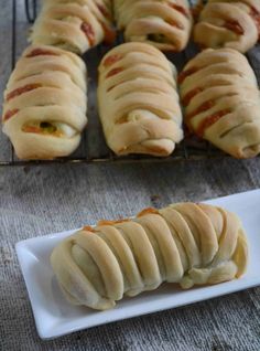 some food is on a white plate and next to a cooling rack with bread rolls