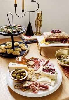 a wooden table topped with lots of different types of food on plates and serving trays