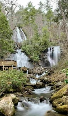 a wooden bench sitting next to a waterfall