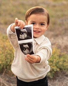 a young boy is holding up an x - ray photo