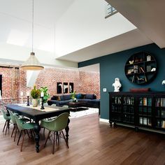 a living room filled with furniture and a dining table next to a bookshelf